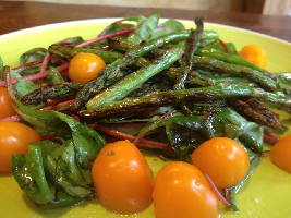 Voedselzandloper salade van snijbiet met gegrilde asperges en oranje cherrytomaatjes